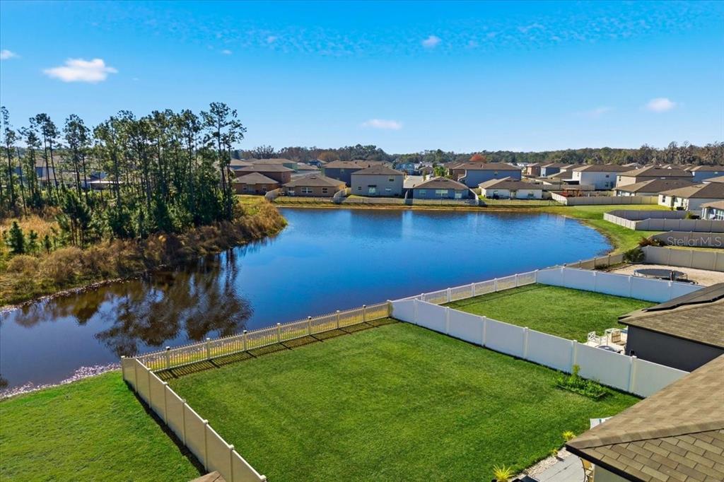 An elevated view of a fenced backyard overlooking a pond and a suburban neighborhood — 2175 OLD MINING ROAD, LAKELAND, FL