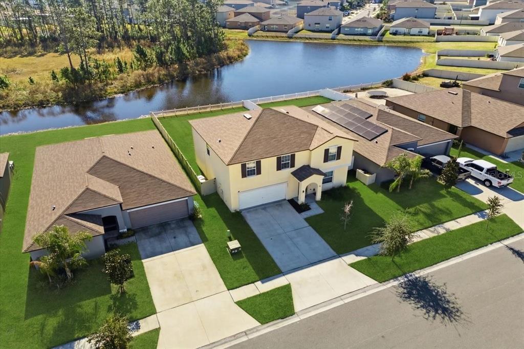 An aerial view shows two suburban houses with driveways and lawns bordering a small lake — 2175 OLD MINING ROAD, LAKELAND, FL