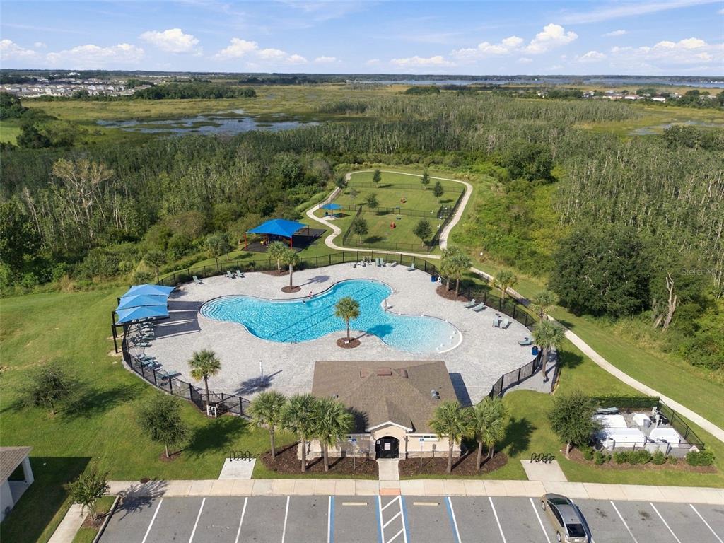 An aerial view shows a community swimming pool, a fenced dog park, and a parking lot — 2566 TRINIDAD ROAD, HAINES CITY, FL