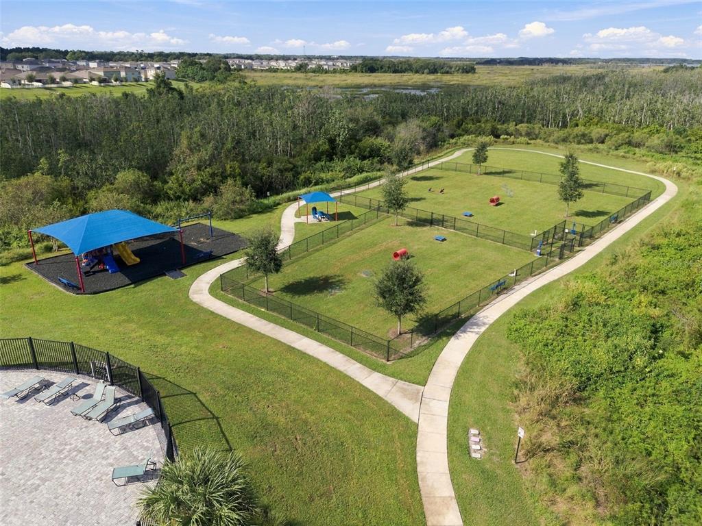 An aerial view shows a fenced dog park with agility equipment next to a playground area — 2566 TRINIDAD ROAD, HAINES CITY, FL