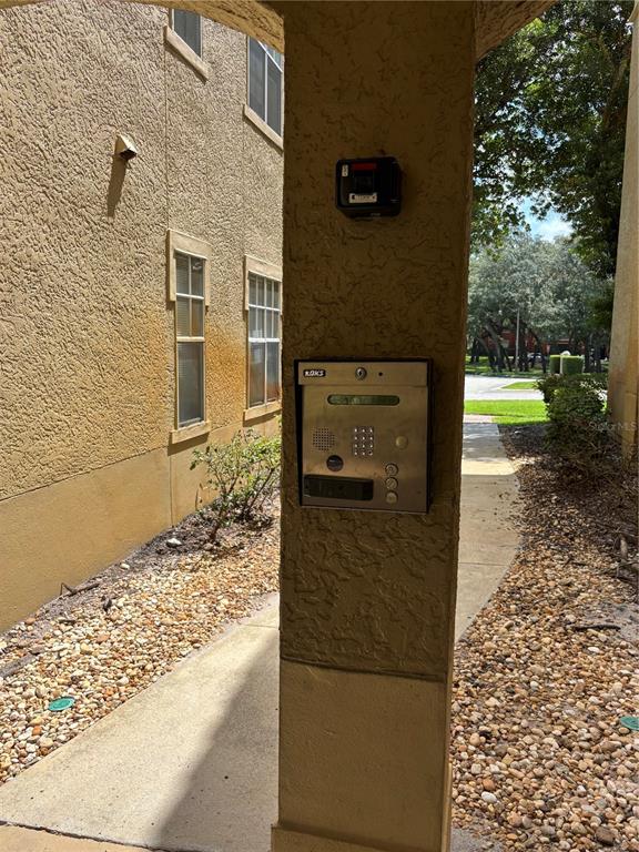 A stucco pillar features an intercom system and a small black box on a walkway — 103 VISTA VERDI CIRCLE UNIT 229, LAKE MARY, FL