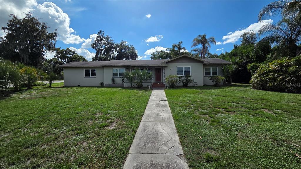 A single-story house with a concrete walkway leading to a red front door — 925 SIKES BOULEVARD, LAKELAND, FL