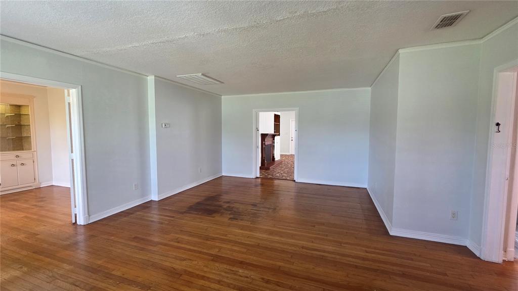 An interior view of a room with hardwood floors, light walls, and two doorways — 925 SIKES BOULEVARD, LAKELAND, FL