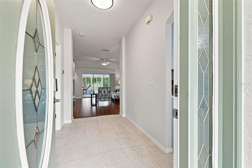 A tiled entryway leads into a living area with hardwood floors and a glass sliding door — 10345 COLLAR DRIVE, SAN ANTONIO, FL