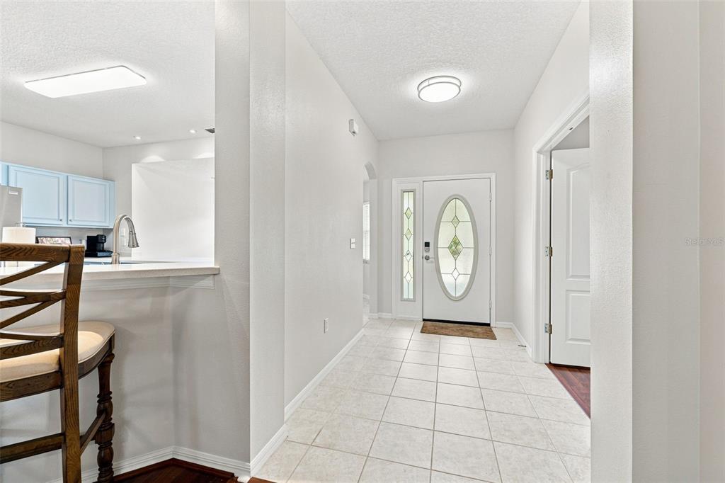 An entryway with tile flooring leads to a white front door with a glass insert — 10345 COLLAR DRIVE, SAN ANTONIO, FL