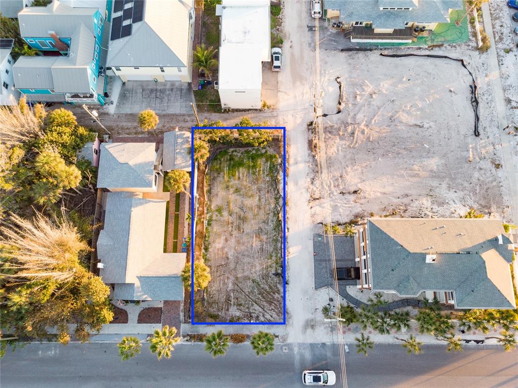 An aerial view shows a vacant rectangular lot outlined in blue between two residential houses — 108 22ND AVENUE, ST PETE BEACH, FL