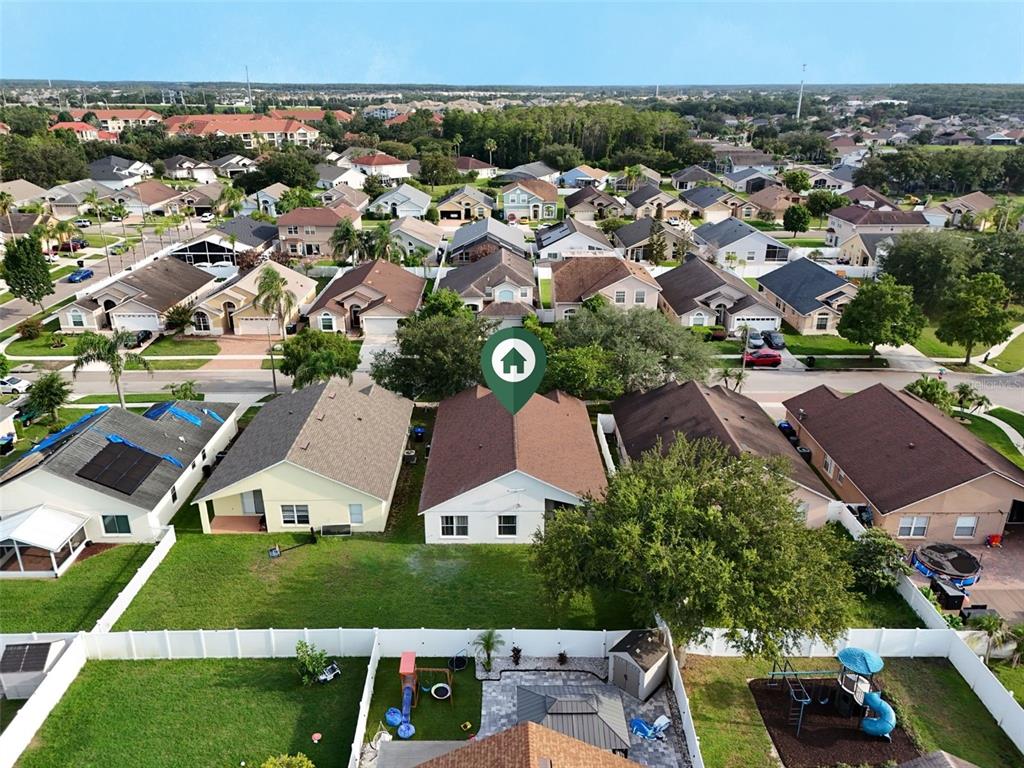 A grassy backyard features a white vinyl fence and a large tree — 3513 MCALLISTER WAY, ORLANDO, FL