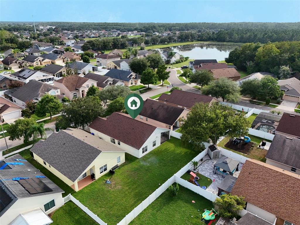 An aerial view shows a residential neighborhood with houses, green lawns, and a nearby lake — 3513 MCALLISTER WAY, ORLANDO, FL