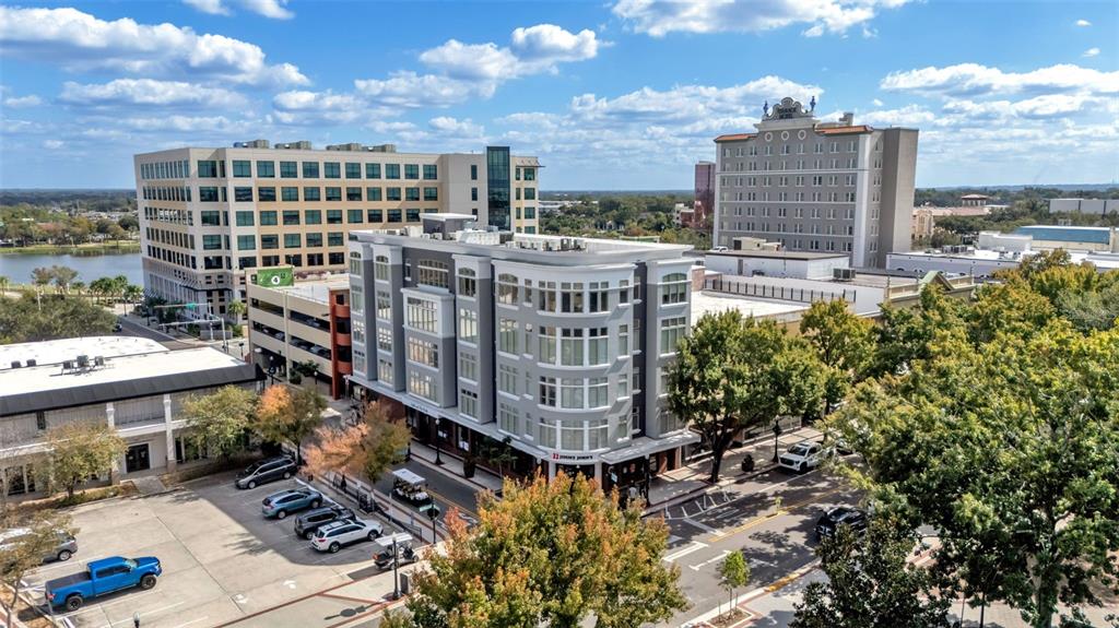An aerial view shows a multi-story apartment building surrounded by city streets and parking lots — 125 N KENTUCKY AVENUE UNIT 505, LAKELAND, FL