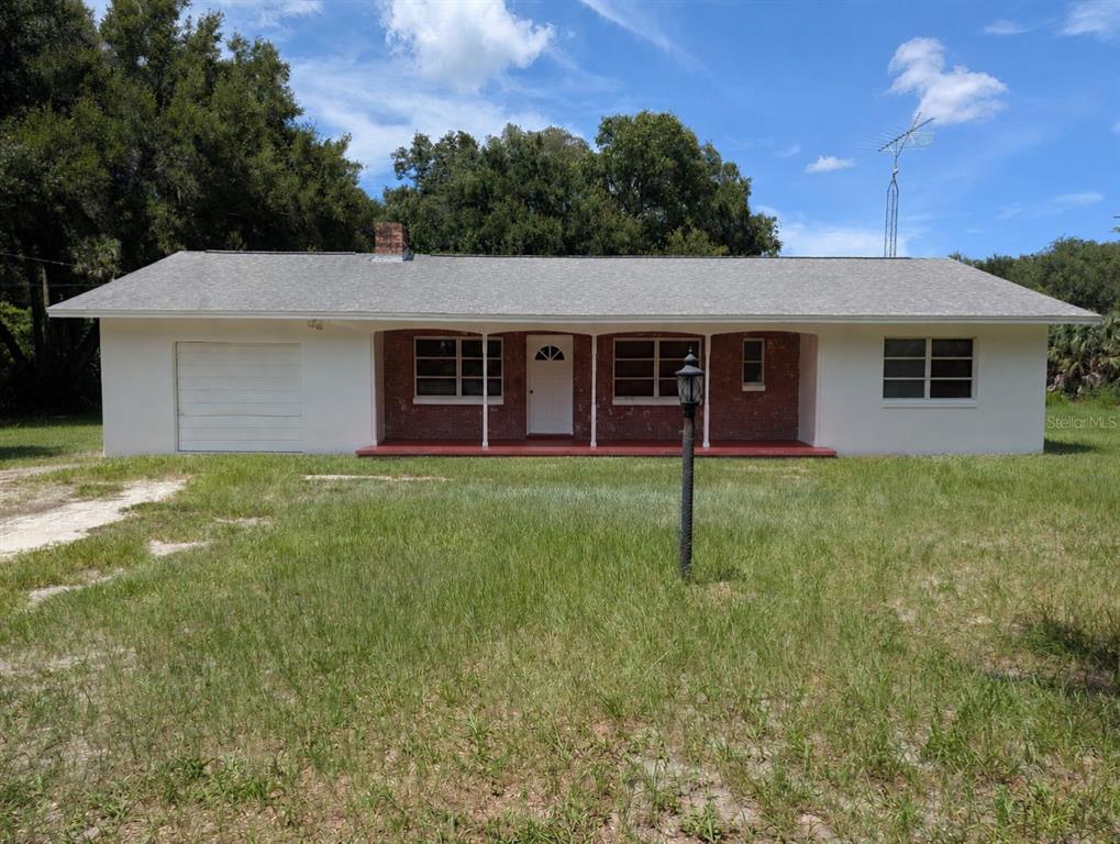 A single-story house with a white exterior, brick accents, and a front porch — 876 SHAW LAKE ROAD, PIERSON, FL