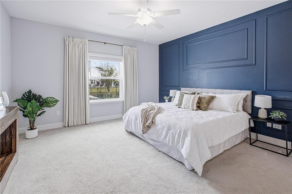 A bedroom features a blue accent wall with molding, a bed, and a window — 126 OLD FORT TRAIL, ST JOHNS, FL