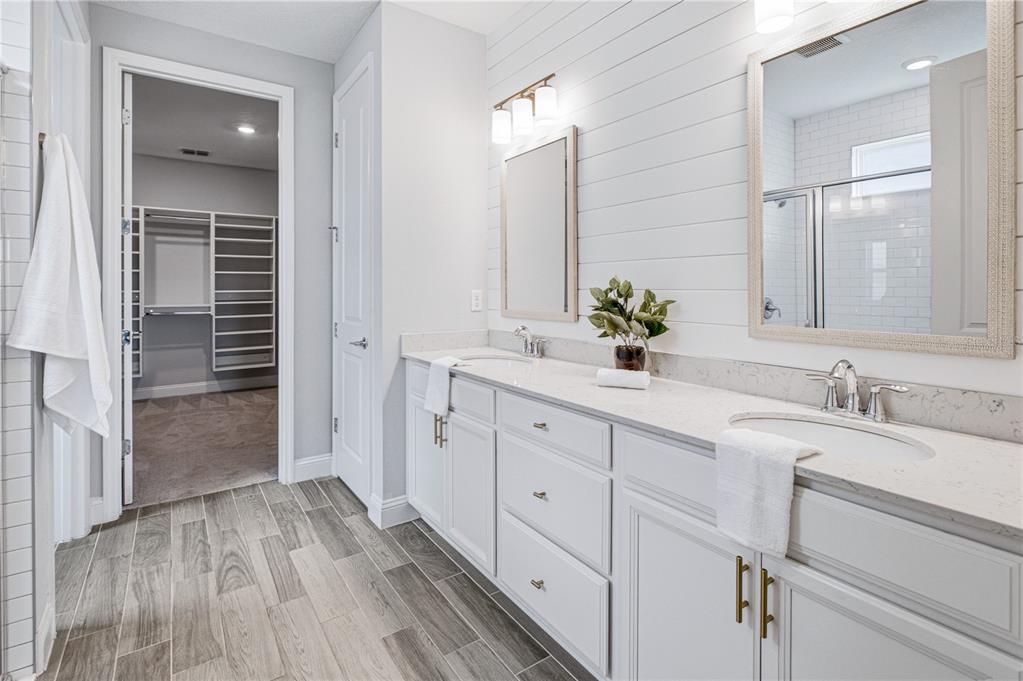A bathroom features a double vanity, shiplap wall, and an adjacent walk-in closet — 126 OLD FORT TRAIL, ST JOHNS, FL