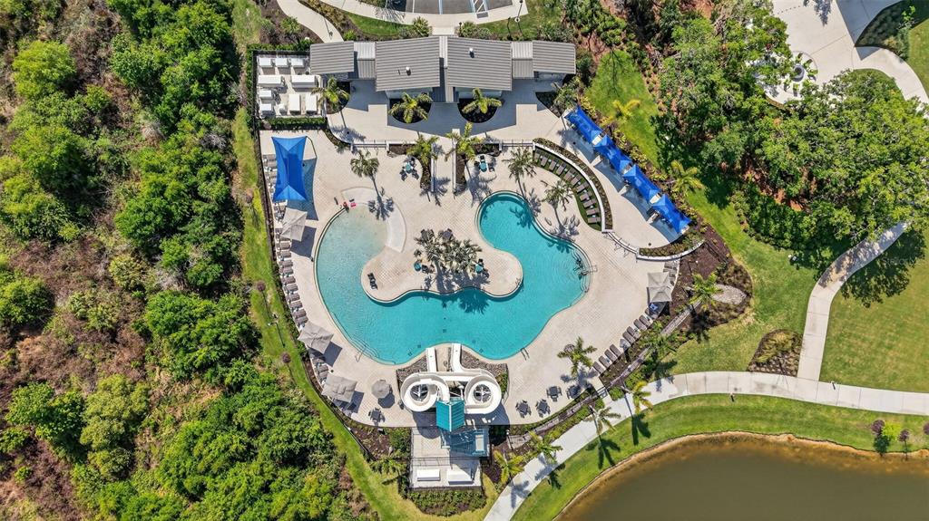 An aerial view shows a swimming pool with a water slide, lounge chairs, and landscaping — 11912 RICHMOND TRAIL, PARRISH, FL