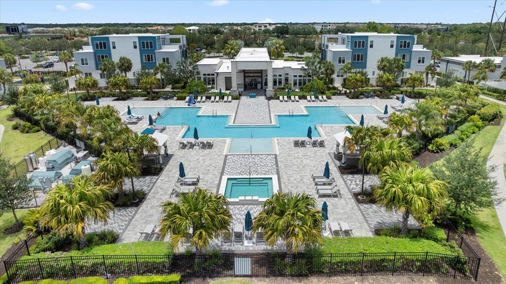 An aerial view of a large swimming pool and hot tub surrounded by apartment buildings — 7740 SANDY RIDGE DRIVE UNIT 112, REUNION, FL