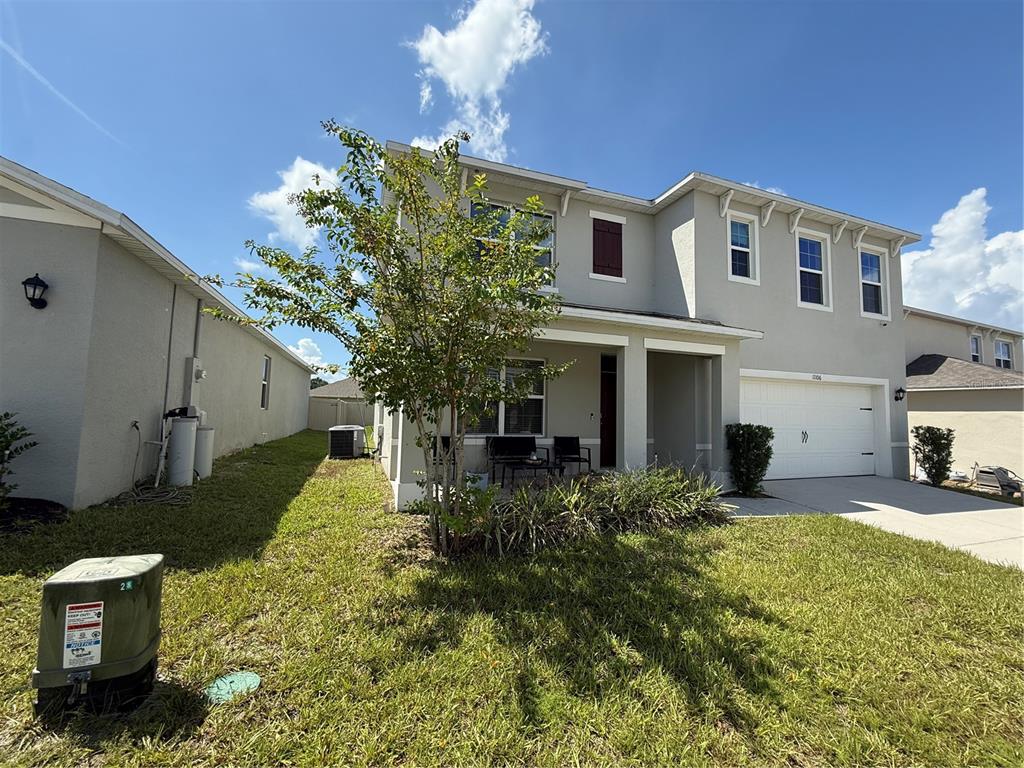 A two-story suburban house with a garage, a small front patio, and a grassy yard — 11106 AMBER RIDGE DRIVE, ZELLWOOD, FL