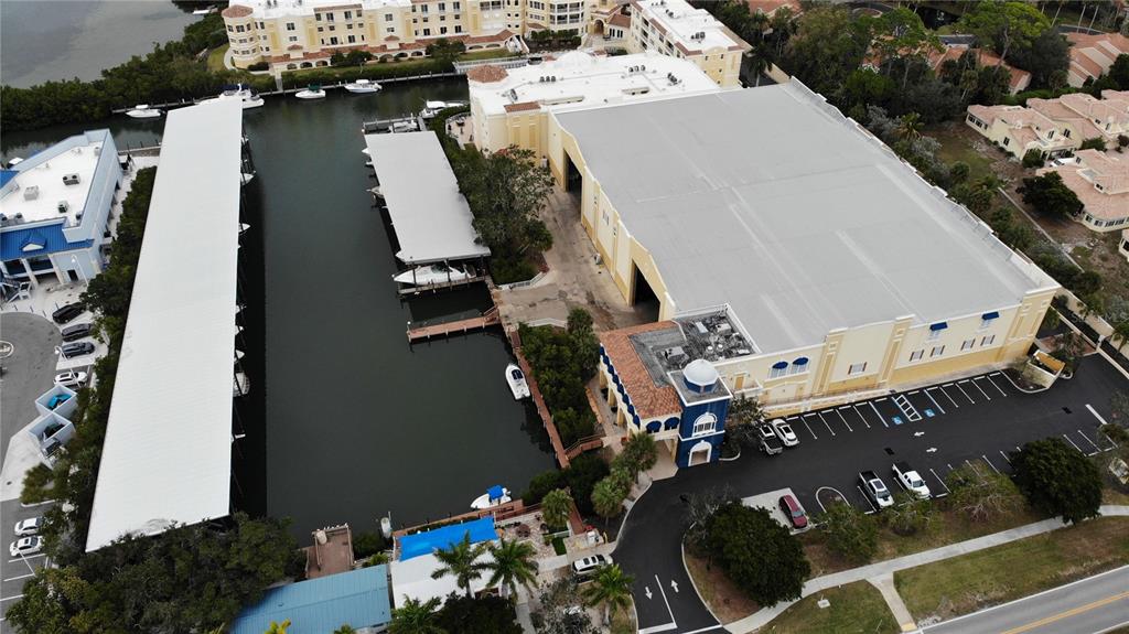 An aerial view shows a large warehouse building adjacent to a boat slip and marina — 570 BLACKBURN POINT ROAD UNIT 13, OSPREY, FL
