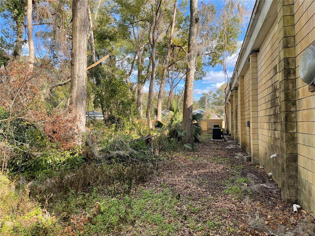 A view of a building's side wall next to a wooded area with trees — lot 1 NW 135TH TERRACE, ALACHUA, FL
