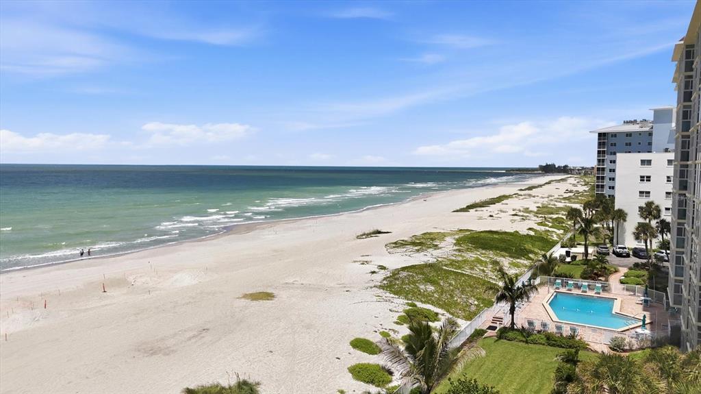 An elevated view of a sandy beach, ocean, and a swimming pool next to buildings — 255 THE ESPLANADE N UNIT 707, VENICE, FL