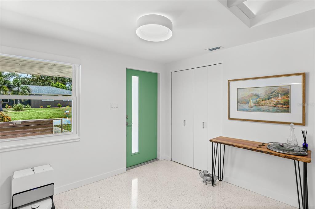 An entryway features a green front door, white walls, terrazzo flooring, and a live-edge console table — 2560 SUNNYSIDE STREET, SARASOTA, FL