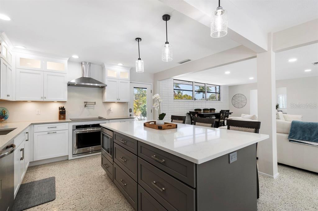 A kitchen with white upper cabinets, a dark gray island, and white quartz countertops — 1165 MORNINGSIDE PLACE, SARASOTA, FL