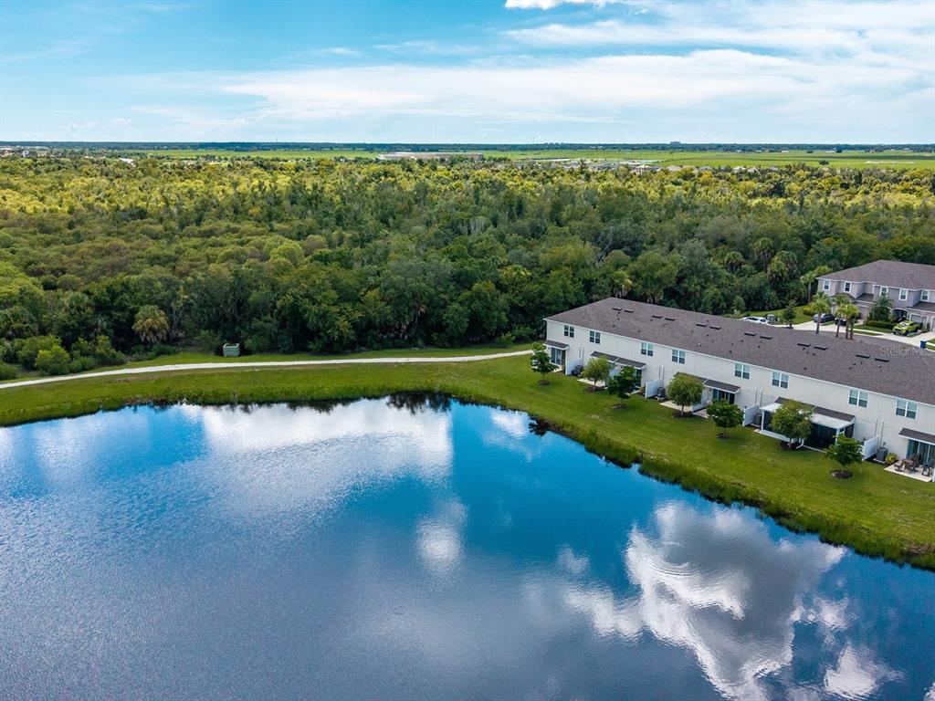 A row of two-story townhomes with beige stucco facades, attached garages, and concrete driveways — 8632 LUNAR SKYE STREET, SARASOTA, FL