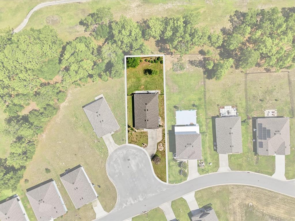 An aerial view shows a single-family home situated on a rectangular lot within a cul-de-sac — 660 HICKORY COURSE LOOP, OCALA, FL