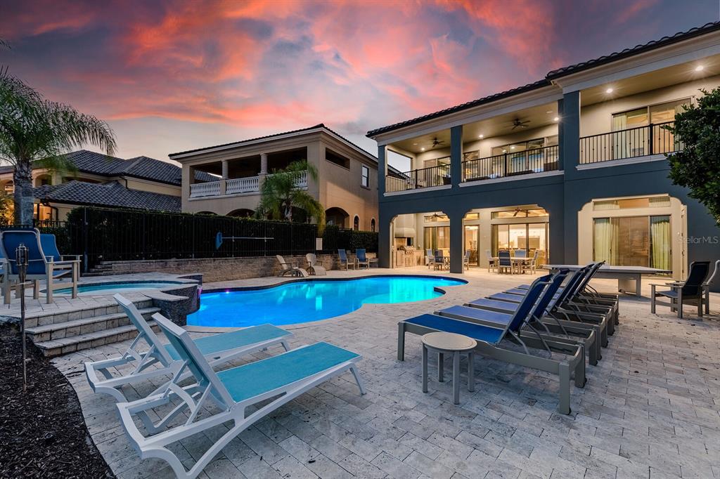 A two-story house with a pool, patio, and lounge chairs at sunset — 445 MUIRFIELD LOOP, REUNION, FL