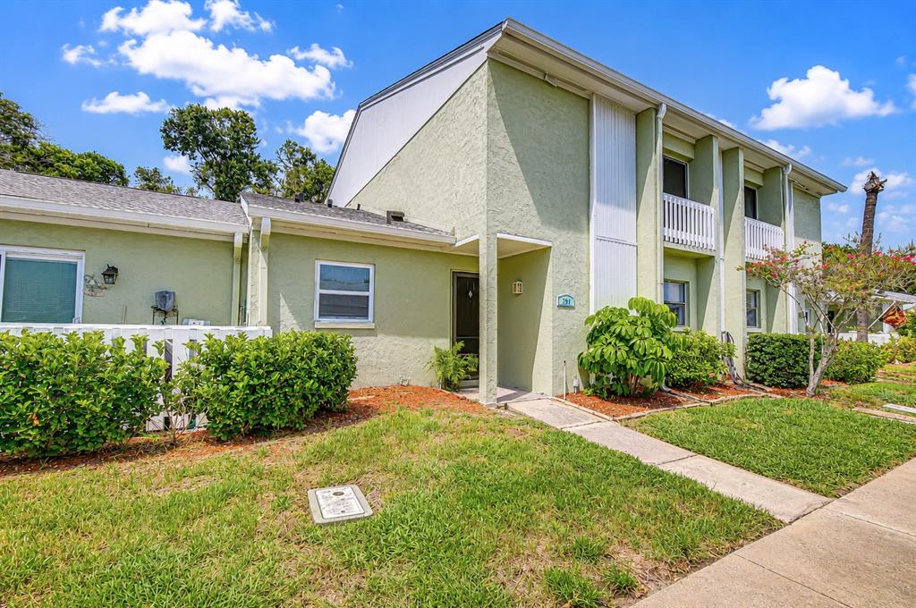 A two-story light green apartment building with a front entrance and landscaped lawn — 230 CYPRESS PLACE, OLDSMAR, FL