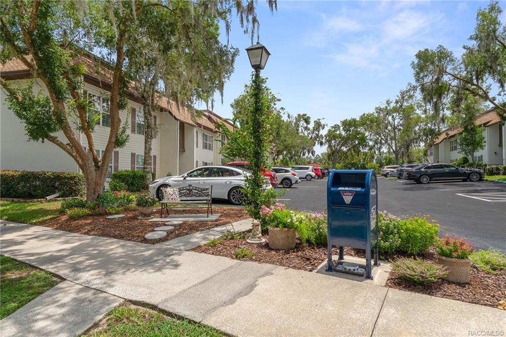 An outdoor parking lot with a blue mailbox, a lamppost, and apartment buildings — 2400 FOREST DRIVE UNIT 222, INVERNESS, FL