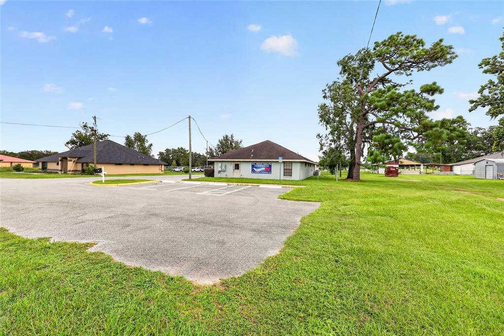 A single-story commercial building with a parking lot sits on a grassy lot — 7133 SE MARICAMP ROAD, OCALA, FL