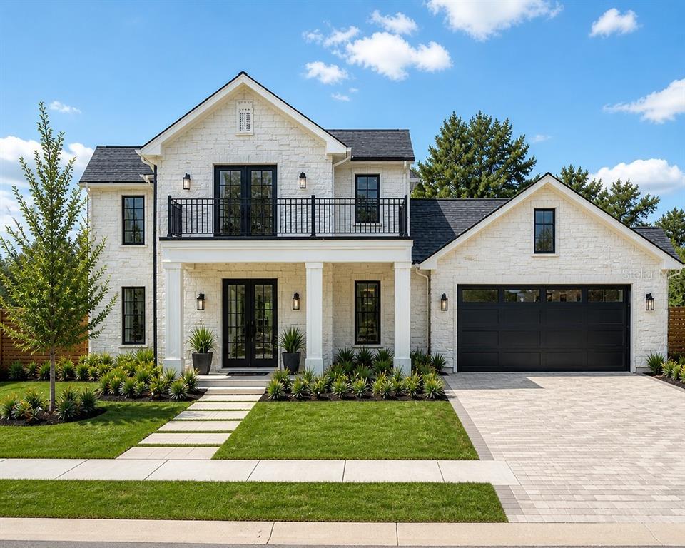 A two-story white brick house features a black roof, balcony, and attached garage — 240 KILLARNEY DRIVE, WINTER PARK, FL
