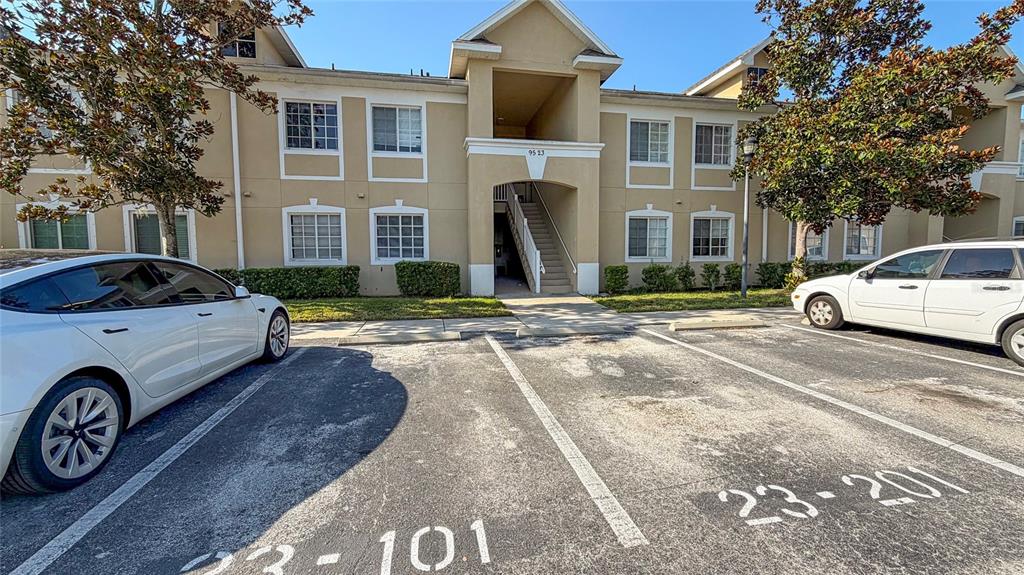 A two-story apartment building exterior with a parking lot in the foreground — 9523 GROVEDALE CIRCLE UNIT 101, RIVERVIEW, FL
