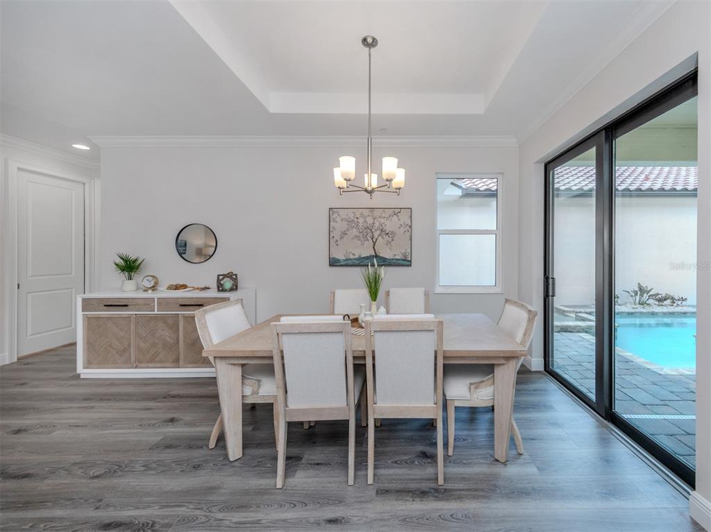 A dining room features a wooden table, six upholstered chairs, a sideboard, and sliding glass doors — 922 E VENICE AVENUE, VENICE, FL