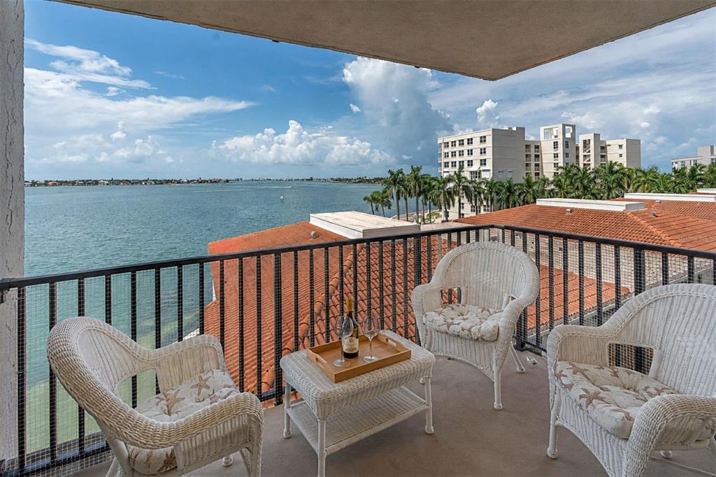 An aerial view shows a waterfront high-rise apartment building with a pool and parking deck — 6287 BAHIA DEL MAR CIRCLE UNIT 401, ST PETERSBURG, FL