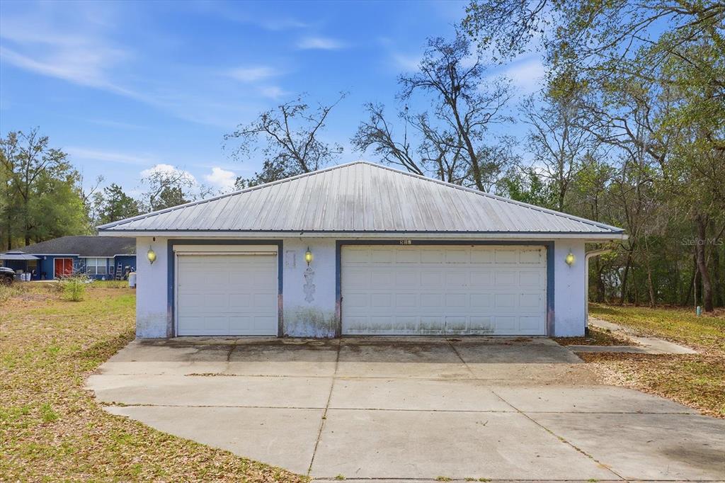 A detached two-car garage with a metal roof sits on a concrete driveway — 5120 E HOPP LANE, INVERNESS, FL
