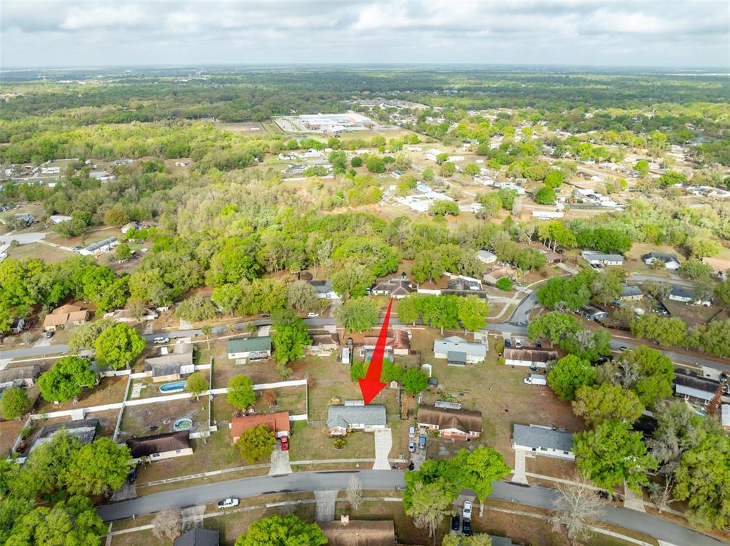 An aerial view shows a residential house with a red arrow pointing to its roof — 5067 BLACK BIRCH TRAIL, MULBERRY, FL