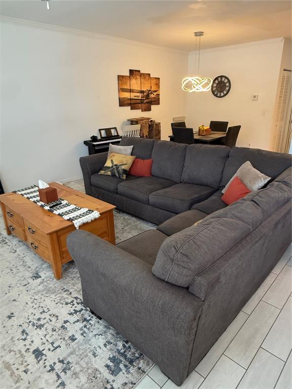 A living room features a large gray sectional sofa, a wooden coffee table, and dining area — 705 CENTERVALE DRIVE, CELEBRATION, FL