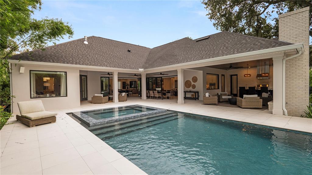 A backyard features a swimming pool with a spa, a covered patio, and outdoor furniture — 2415 NEVADA ROAD, LAKELAND, FL