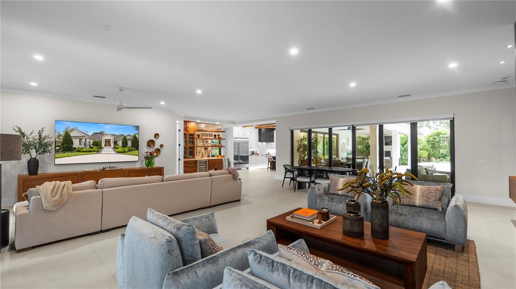 A spacious living room features a large sectional sofa, a wooden coffee table, and sliding doors — 2415 NEVADA ROAD, LAKELAND, FL