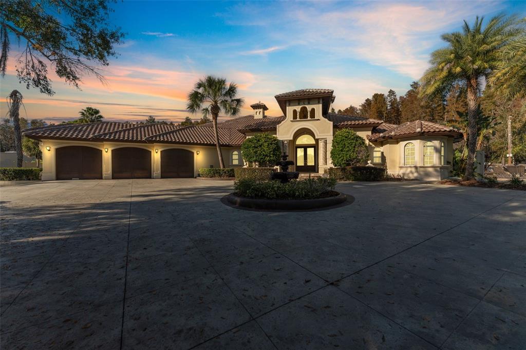 A large Mediterranean-style house with a three-car garage and a circular driveway with a fountain — 19165 GERACI ROAD, LUTZ, FL