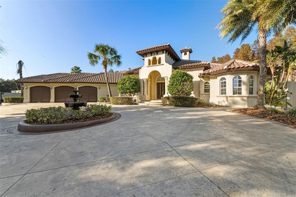 A Mediterranean-style house with a three-car garage, a circular driveway, and a central fountain — 19165 GERACI ROAD, LUTZ, FL
