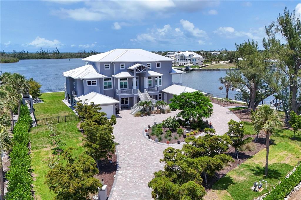 An aerial view of a large gray house with a white roof and paved driveway — 565 GREEN DOLPHIN DRIVE S, PLACIDA, FL