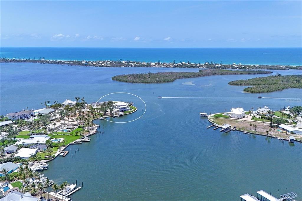 An aerial view shows a waterfront house on a point surrounded by a bay — 565 GREEN DOLPHIN DRIVE S, PLACIDA, FL
