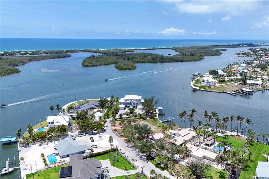 An aerial view shows waterfront homes with swimming pools, docks, and boats on a bay — 565 GREEN DOLPHIN DRIVE S, PLACIDA, FL