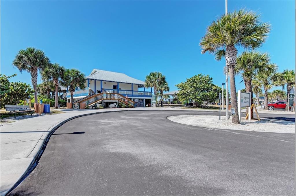 A paved driveway leads to a two-story building with a staircase at a beach park — 10435 PENDLETON AVENUE, ENGLEWOOD, FL