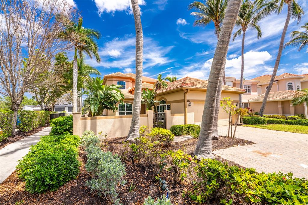 A two-story stucco house with a tile roof and palm trees in the front yard — 3337 SUNSET KEY CIRCLE, PUNTA GORDA, FL
