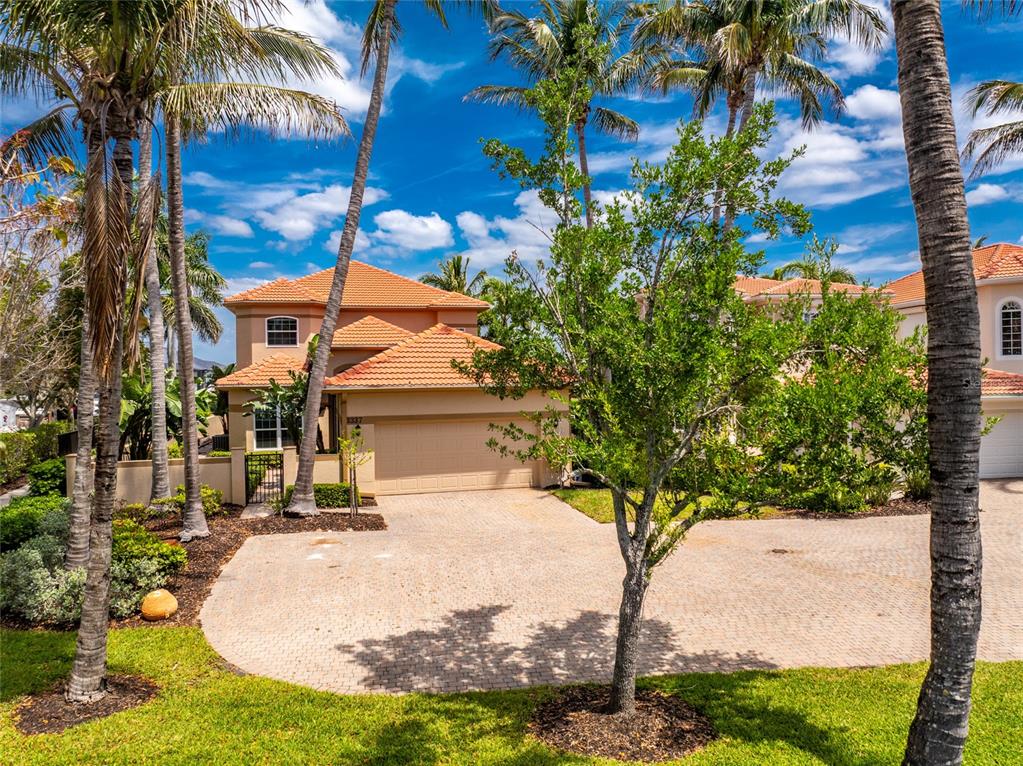 A two-story house with a tile roof and a paved driveway surrounded by palm trees — 3337 SUNSET KEY CIRCLE, PUNTA GORDA, FL
