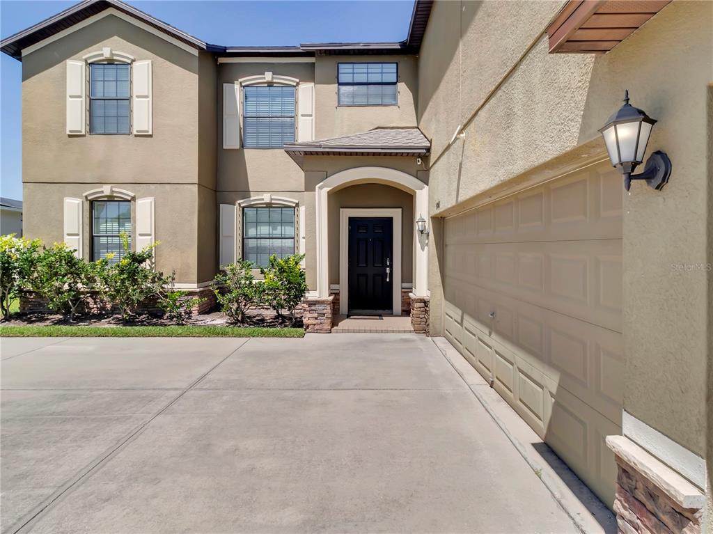 An aerial view shows a two-story house with a screened-in pool and fenced backyard — 5063 IVORY STONE DRIVE, WIMAUMA, FL