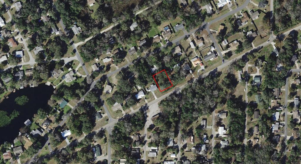 An aerial view shows a vacant rectangular lot outlined in red within a residential neighborhood — 8731 E GOSPEL ISLAND ROAD, INVERNESS, FL