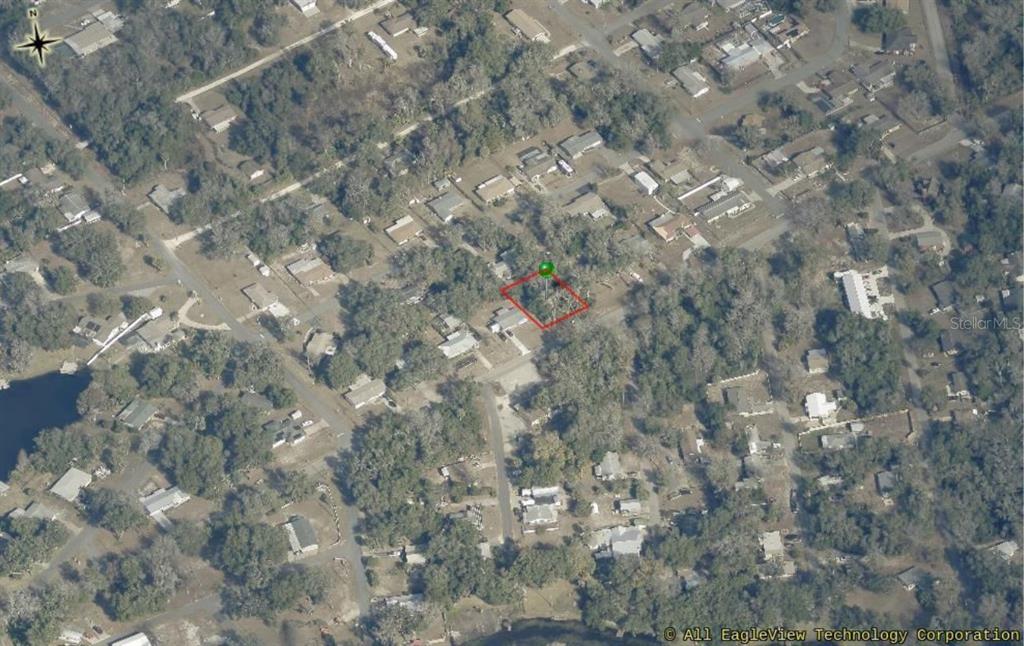 An aerial view shows a rectangular property lot outlined in red within a residential neighborhood — 8731 E GOSPEL ISLAND ROAD, INVERNESS, FL